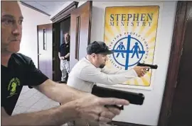  ?? Photograph­s by Smiley N. Pool Dallas Morning News ?? LES DAVIS, left, and Jason Johnston raise weapons during training on searching and clearing a hallway at Cornerston­e Community Church in Springtown, Texas.