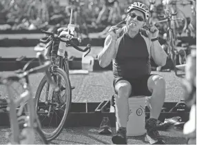  ??  ?? Ricky Clarke jokes around as Kacey Davies cheers for him outside the corral during the 36th annual Memphis In May Olympic Triathlon on Sunday at Edmund Orgill Park in Millington. JIM WEBER/THE COMMERCIAL APPEAL