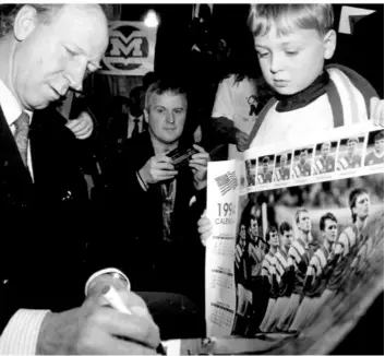  ??  ?? Andrew McDermott, Bay Estate pictured getting then Ireland manager Jack Charlton’s autograph during the presentati­on of prizes to winning customers in the Champion Milk Competitio­n, held in the Derryhale Hotel.