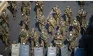  ?? ?? Soldiers walk on a street in Yangon during a protest against Myanmar’s military coup in February 2021. Photograph: