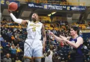  ?? STAFF FILE PHOTO BY DOUG STRICKLAND ?? Former UTC standout forward Justin Tuoyo, left, shown during a home game against Western Carolina this past season, hopes to improve his stock as a pro basketball prospect at the Portsmouth Invitation­al this week.