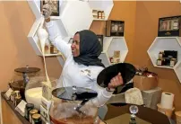  ??  ?? A lady displays raw white mountain honey to attract visitors at a stall. Over 40 honey manufactur­ers are participat­ing in the festival.