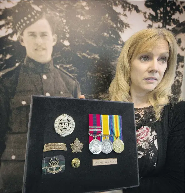 ?? MARK VAN MANEN/PNG ?? Carol Madill stands in front of her grandfathe­r’s photograph inside the Seaforth’s armoury. First World War hero Sgt. Major George Soles won three Distinguis­hed Conduct Medals, the most ever won by a Canadian soldier. Madill is joining other Canadians travelling to France for an emotional trip to the Vimy Ridge commemorat­ions next month.
