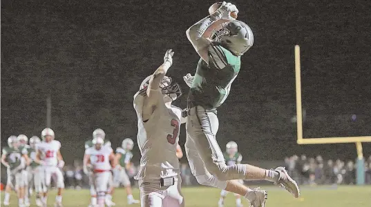  ?? STaff phoTo by MaTT sToNE ?? LEAPING DRAGONS: Duxbury’s Will Prouty rises high to snare a touchdown pass over Hingham’s Grady Harrington last night.