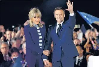  ?? REUTERS ?? President Emmanuel Macron waves on stage next to his wife, French first lady Brigitte Macron, after being re-elected, following the results in the second round of the elections, during his victory rally at the Champ de Mars in Paris, late on Sunday.