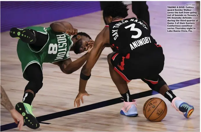  ?? GETTy imAgES ?? TAKING A DIVE: Celtics guard Kemba Walker saves the ball from going out of bounds as Toronto’s OG Anunoby defends during the third quarter of Game 3 of their Eastern Confernece semifinal series Thursday night in Lake Buena Vista, Fla.