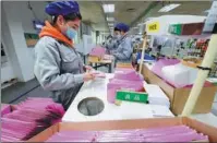  ?? JI HAIXIN / FOR CHINA DAILY ?? Quality-control workers check packaging products at Jiangsu province-based Starlite Printers (Suzhou) Co Ltd.