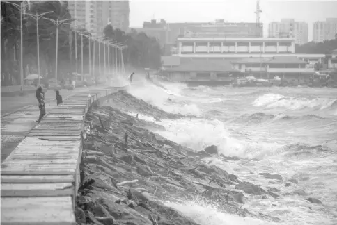  ?? — AFP photo ?? Strong waves pound the waterfront as weather patterns from Typhoon Yutu affect Manila Bay.