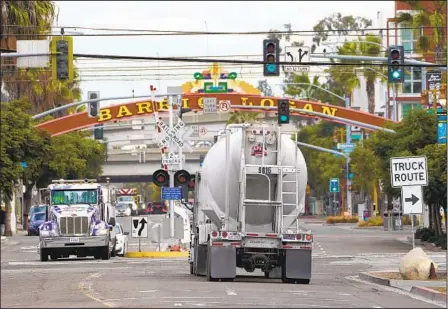  ?? NELVIN C. CEPEDA U-T ?? Grandes camiones semirremol­que que transporta­n mercancías, circulan por Harbor Drive y Cesar E. Chavez Parkway en Barrio Logan el martes 8 de diciembre de 2020 en San Diego, CA.