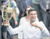  ?? ALBERTO PEZZALI — THE ASSOCIATED PRESS ?? Novak Djokovic shows off the winner’s trophy after his victory over Matteo Berrettini in the men’s singles final at Wimbledon.
