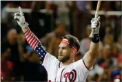  ?? AP PHOTO BY ALEX BRANDON ?? Washington Nationals Bryce Harper (34) signals to the crowd as he walks back to the dugout during the MLB Home Run Derby, at Nationals Park, Monday, July 16,