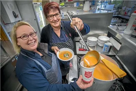  ?? MURRAY WILSON/STUFF ?? Captain Michelle Lee, left, and Kat Eden, serving up at the Catherine Booth Soup Cafe in the kitchen of the Palmerston North Salvation Army.