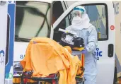  ?? CARLOS OSORIO / REUTERS ?? A paramedic transports a patient to Toronto’s Mount Sinai Hospital on Friday as the number of COVID-19
cases in Ontario continues to grow.