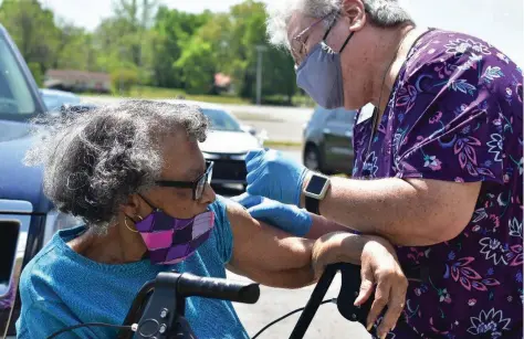  ?? (Pine Bluff Commercial/I.C. Murrell) ?? Ernestine Braswell, 84, of Pine Bluff, receives her covid-19 vaccinatio­n from Area Agency on Aging nurse Kashimi Elkins on Tuesday just outside the Sgt. Michael J. Strachota Senior Center.