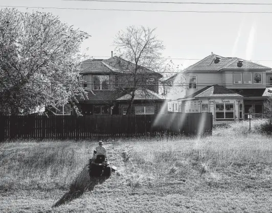  ?? Jessica Phelps / Staff photograph­er ?? John Brouse mows the lawn at his home in the Wind Gate Ranch community on the far West Side. Beyond him is new home constructi­on in another subdivisio­n.