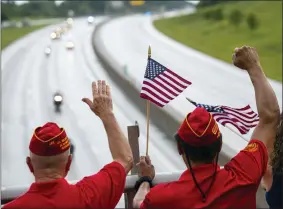  ?? SHOLTEN SINGER — THE HERALD-DISPATCH VIA AP ?? Marine Corps League veterans wave as the funeral procession for Medal of Honor recipient Hershel “Woody” Williams moves along Interstate 64on July 2in Teays Valley,