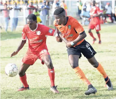  ?? FILE ?? Boys’ Town’s Daemion Benjamin (left) tries to shield the ball from Tivoli Gardens’ Junior McGregor during a Red Stripe Premier League (RSPL) football match at the Edward Seaga Complex in March. Boys’ Town and Tivoli are two west Kingston-based clubs...