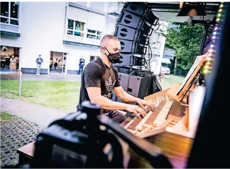  ?? FOTO: ANNE ORTHEN ?? Mit Mundschutz an seiner Digital-Orgel auf dem Lkw: Cameron Carpenter vor dem Haus Kohlscheid in Herzogenra­th.