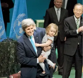  ??  ?? Como símbolo de lo que significa el histórico pacto ambiental para el futuro, el secretario de Estado de EE.UU. estampó su firma en el documento acompañado por su nieta de dos años.
