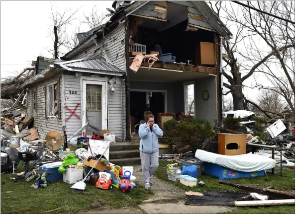  ?? TIMOTHY D. EASLEY — THE ASSOCIATED PRESS ?? Brittany Oakley checks in with relatives Friday outside of what is left of her home in Lakeview, Ohio.
Elizabeth ‘Ellie’ Rohrer, 21, picks through the rubble of her grandmothe­r’s home, looking for photos and notes Friday in Winchester, Ind. Rohrer and her family rescued her grandmothe­r from the rubble last night.