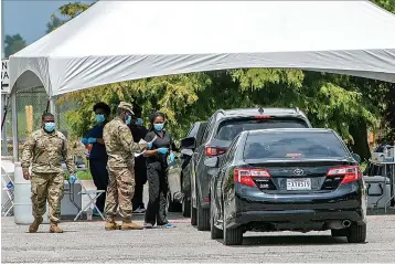  ?? Associated Press ?? ■ People line up July 7 at the COVID-19 testing site at LSU's Alex Box Stadium parking lot in Baton Rouge, La.