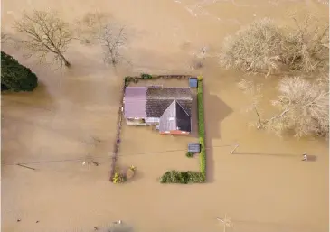  ??  ?? Marooned: An aerial view of a house in Bewdley, now surrounded by the Severn