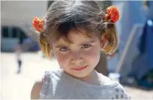  ??  ?? A Syrian girl, displaced from Ghouta, looks at the camera in a make-shift camp built inside a school in the northern Syrian town of Atareb on Saturday. — AFP