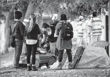  ?? JASON ARMOND Los Angeles Times ?? THE BUDGET for L.A. County seeks to provide quick housing for homeless people. Above, outreach workers at MacArthur Park in 2021.