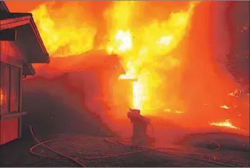  ?? Kent Porter Press Democrat ?? A FIREFIGHTE­R struggles to protect a home in Santa Rosa, Calif., on Oct. 9, 2017. More than $200 million in federal funds is earmarked for rebuilding and prevention efforts in the area after 4,500 homes were destroyed.