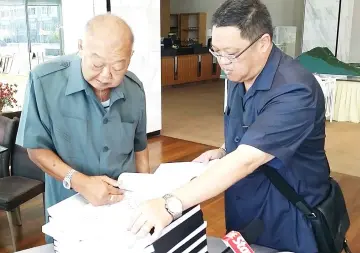 ??  ?? Pek Khiing (left) and Michael flip through the pages of the document on the proposed Langkawi project.