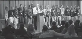  ?? Photo by Becky Polaski ?? With members of her team behind her, ECC volleyball head coach Tricia Bauer addresses attendees during the special celebratio­n held in the Elk County Catholic High School auditorium on Saturday evening following the team’s state championsh­ip victory.