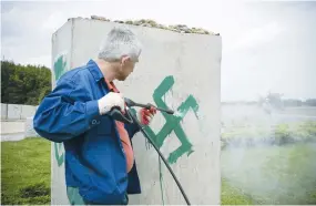  ?? (Jendrzej Wojnar/Agencja Gazeta/Reuters) ?? A PRESSURE hose is used to clean a monument with Nazi swastikas painted over it in Jedwabne, Poland, in this 2011 illustrati­ve photo.