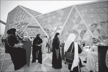  ?? Amr Nabil Associated Press ?? MOVIEGOERS await the opening of the AMC Cinema in Riyadh, Saudi Arabia. The return of movie houses to the conservati­ve kingdom is part of a broad modernizat­ion drive by Crown Prince Mohammed bin Salman.