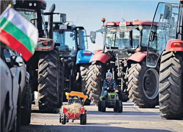  ?? ?? Children play with toy tractors at a blockade near the town of Breznik, Bulgaria, where farmers moved farming vehicles onto motorways