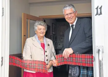  ?? ?? FRESH LEASE OF LIFE: Lord Lieutenant of Banffshire Andrew Simpson cuts the ribbon to formally open the centre, watched by Brenda Wood of the heritage group.