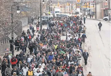  ?? RYAN GARZA, DETROIT FREE PRESS ?? Hundreds march along West Vernor Highway in Detroit on Thursday after a rally at Clark Park. About 100 businesses closed in southeast Michigan.