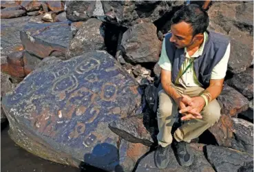  ?? AP PHOTO/EDMAR BARROS ?? Archaeolog­ist Jaime Oliveira sits next to rock paintings Saturday at the Ponta das Lajes archaeolog­ical site in the rural area of Manaus, Brazil.