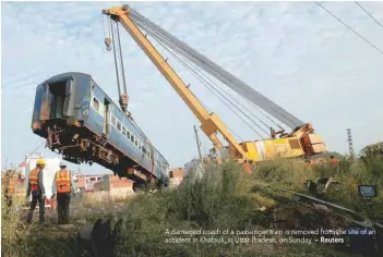  ?? — Reuters ?? A damaged coach of a passenger train is removed from the site of an accident in Khatauli, in Uttar Pradesh, on Sunday.