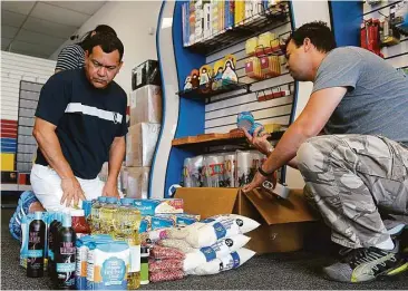  ?? James Nielsen / Houston Chronicle ?? Yersys Rivas (izq.) y Jhimy Gelabert empaquetan alimentos y artículos sanitarios para enviarlos a Venezuela.
