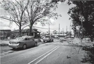  ?? Eva Marie Uzcategui / Bloomberg ?? Utility poles and street lamps block a road Sept. 2 after Hurricane Ida damaged Laplace, La. The storm, which killed at least 95 people, cost the economy an estimated $65 billion.