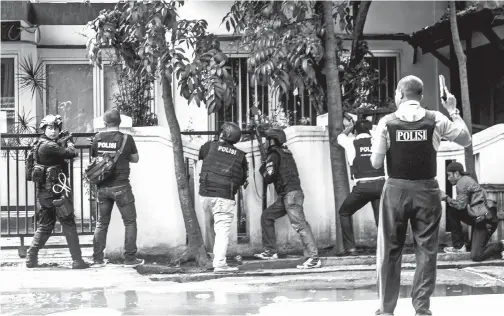  ?? — Gambar Reuters ?? GAMBAR serahan Antara Foto menunjukka­n beberapa anggota polis mengawal keadaan berhampira­n pejabat kerajaan tempatan susulan letupan bom di Bandung, Jawa Barat semalam.