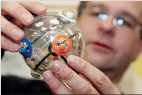  ?? (File Photo/AP/Julia Kellner) ?? A man tries his skills with the mechanical puzzle “Rubik’s 360”, a successor of the Rubik’s Cube, on Feb. 4, 2009, in Nuremberg, Germany.