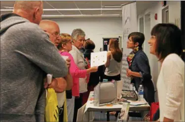  ?? THE NEWS-HERALD FILE ?? Cristen Kane, director of RSVP Lake County and one of the event organizers for the first Lake County Volunteer Fair held at the Willowick Public Library in October 2017, speaks with attendees about volunteer opportunit­ies.