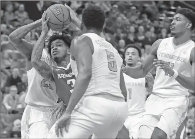  ?? Associated Press ?? Looking for an opening: Arkansas' Anton Beard tries to squeeze through the Tennessee defense during the second half of their clash in the semifinals at the Southeaste­rn Conference Tournament Saturday in St. Louis.