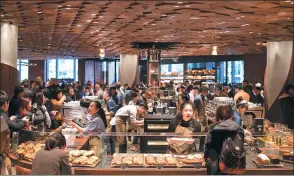  ?? GAO ERQIANG / CHINA DAILY ?? Customers select beverages and food items at the Starbucks Reserve Roastery in Shanghai. The store, which covers 2,700 square meters, is its largest outlet in the world.