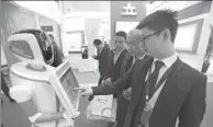  ?? PROVIDED TO ?? Visitors contact with a bank’s robot at an exhibition in Beijing. Financial institutio­ns are required to remind investors of the flaws and risks associated with algorithm-based robo-advisory models.