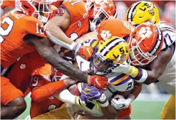  ?? AP Photo/Gerald Herbert, File ?? ■ LSU wide receiver Justin Jefferson (2) is tackled by Clemson defenders during the first half of the College Football Playoff national championsh­ip game Jan. 13 in New Orleans.