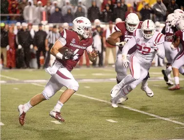  ?? AP Photo/Michael Woods ?? ■ Arkansas quarterbac­k Ty Storey carries the ball against Mississipp­i during the football game Saturday in Little Rock. first half of an NCAA college