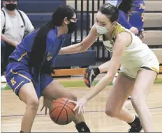  ?? PHOtO BY randY HOEFt/YUMA SUN ?? YUMA CATHOLIC’S RIAN MARTINEZ (right) gets a hand on the dribble of Kingman’s Nyamisi Havaton during the first quarter of Friday night’s game at Yuma Catholic.