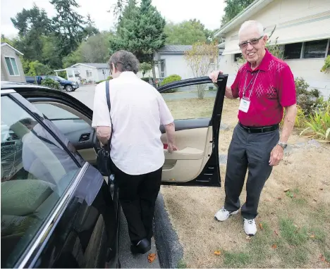  ?? JASON PAYNE ?? George Garrett helps a woman get into his car before he takes her to a doctor’s appointmen­t in Surrey. Since his retirement as a CKNW news reporter, Garrett has led a busy volunteer life, helping out Alzheimer’s and cancer patients.